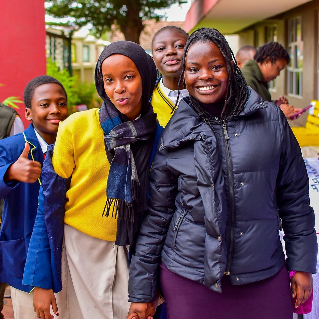 A teacher with some students posing for the camera