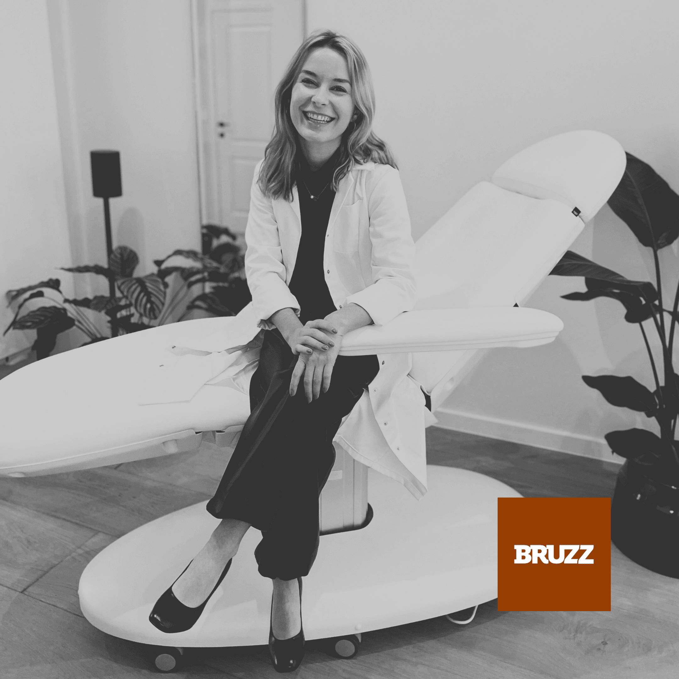 Dr. Louise Cuveele sitting on a treatment chair in her practice with BRUZZ logo.