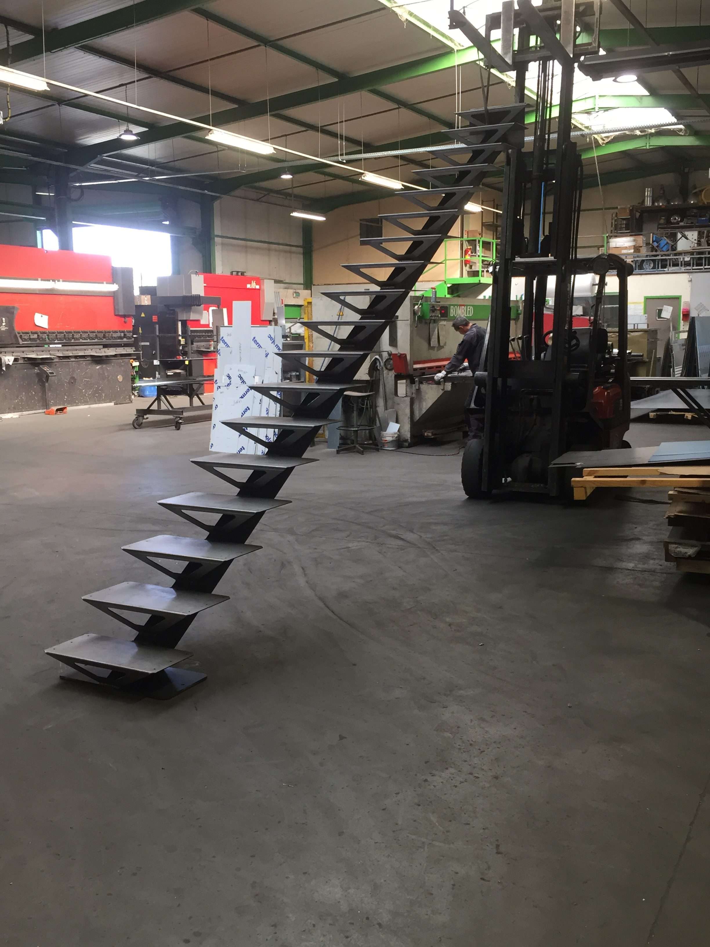 A metallic spiral staircase ascends outdoors.