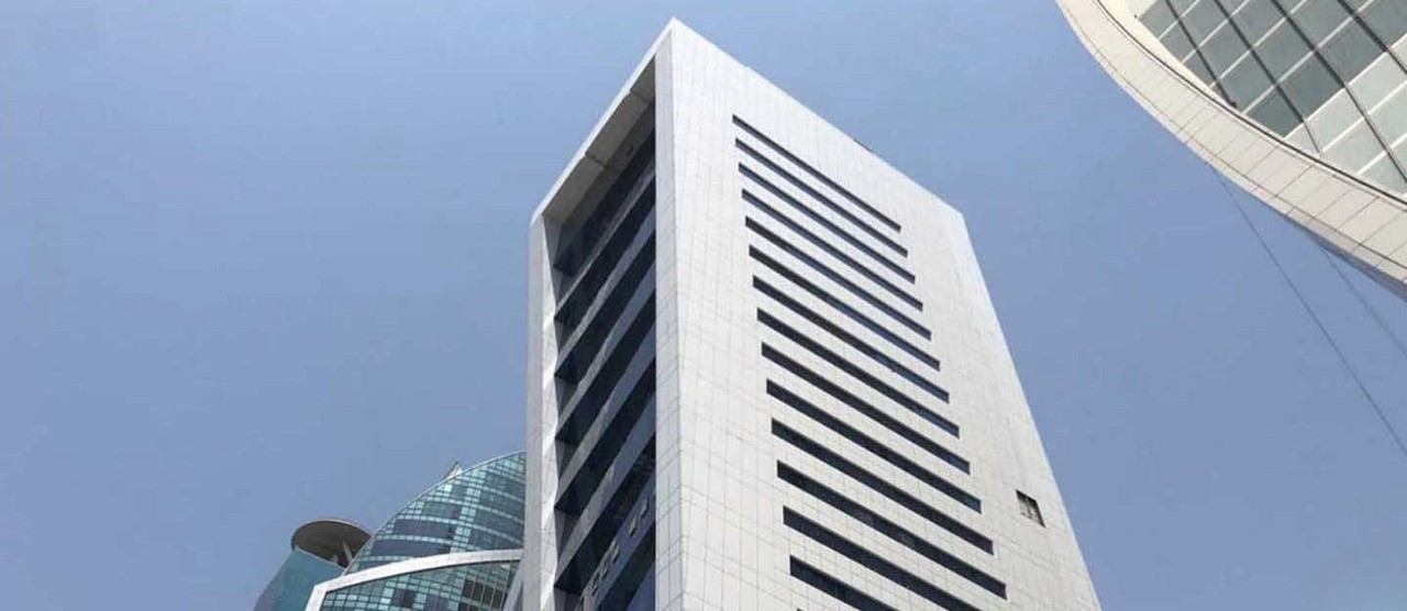 Low angle view of the modern commercial facade at The Exchange Tower in Business Bay.