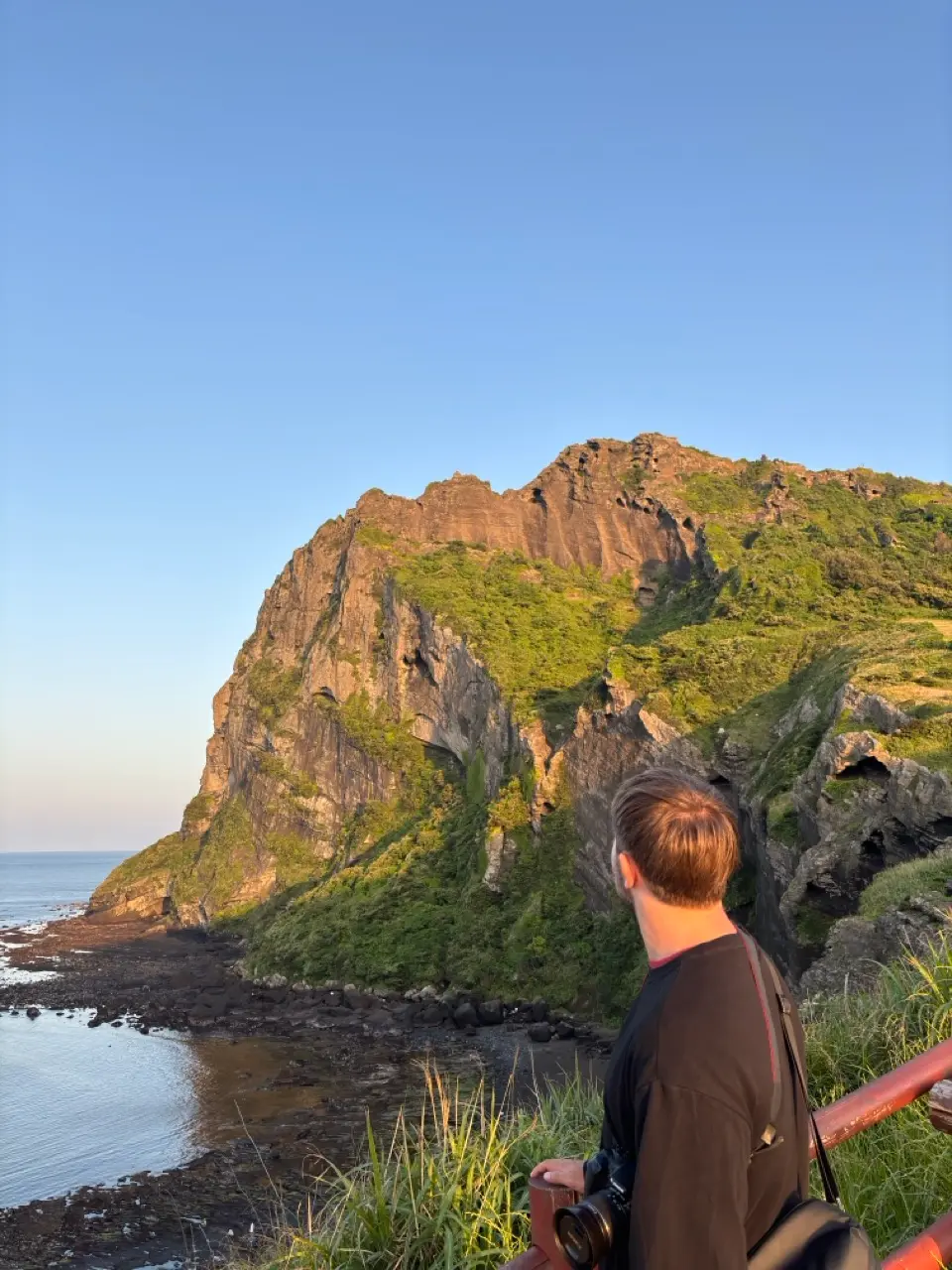 man bij zonsondergang bij vulkanische krater jeju island