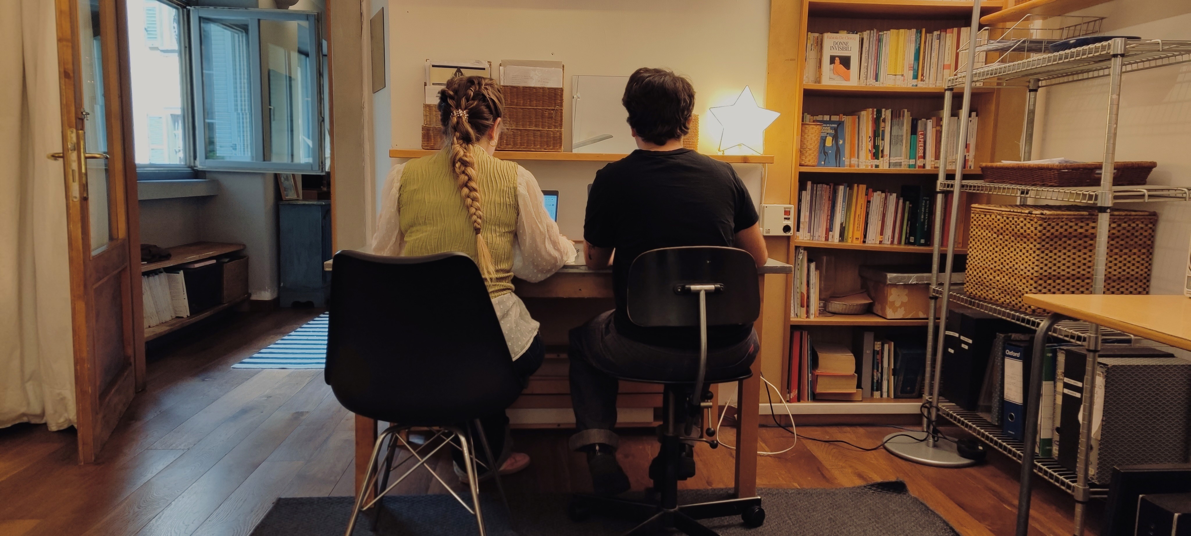 Close-up of a scientist holding a tray of petri dishes with purple cultures, wearing gloves and safety gear.