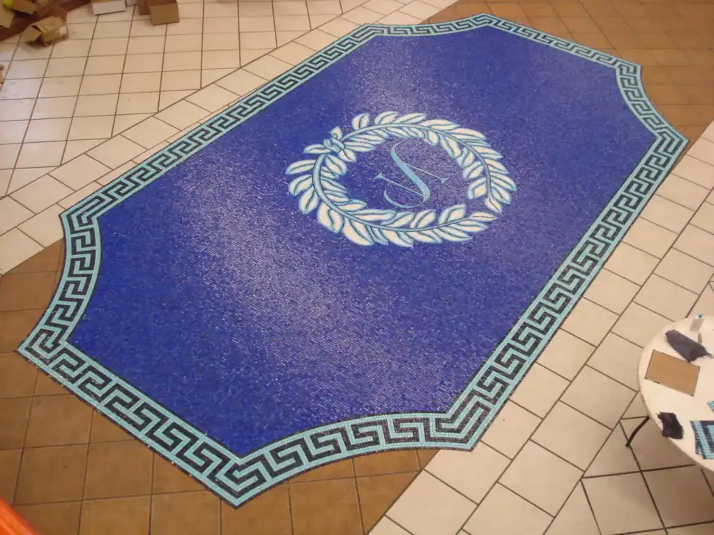 Greek style pool mosaic with key border and Roman-inspired central design.