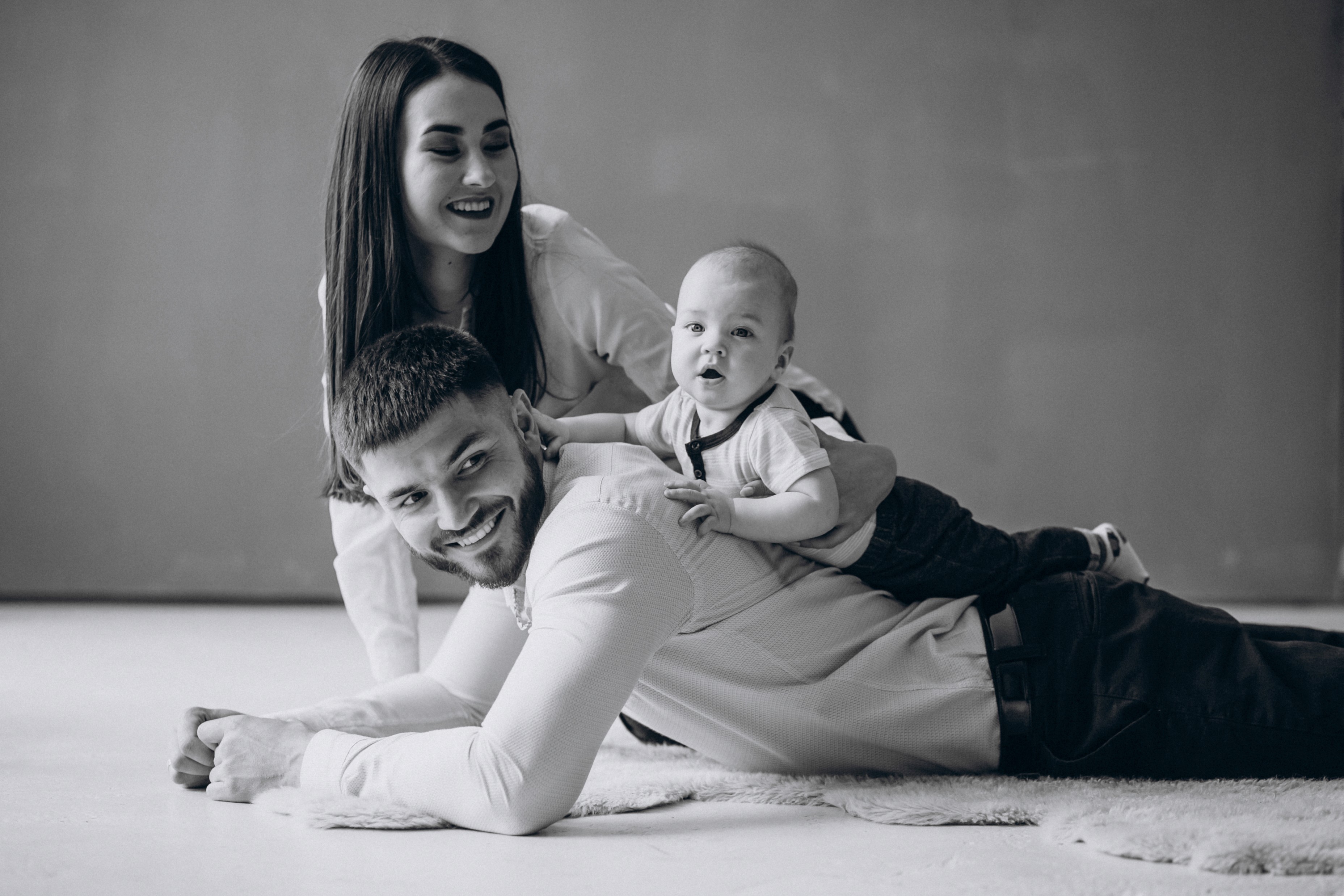 Black and white family photos of parents and baby studio portrait