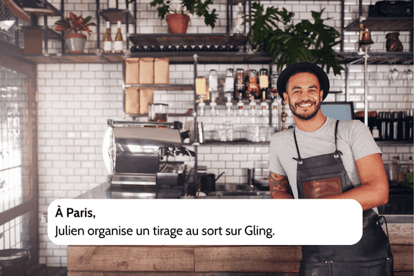 Photo d’un commerçant souriant à Paris derrière son comptoir, illustrant Julien qui organise un tirage au sort sur Gling pour animer sa communauté locale.