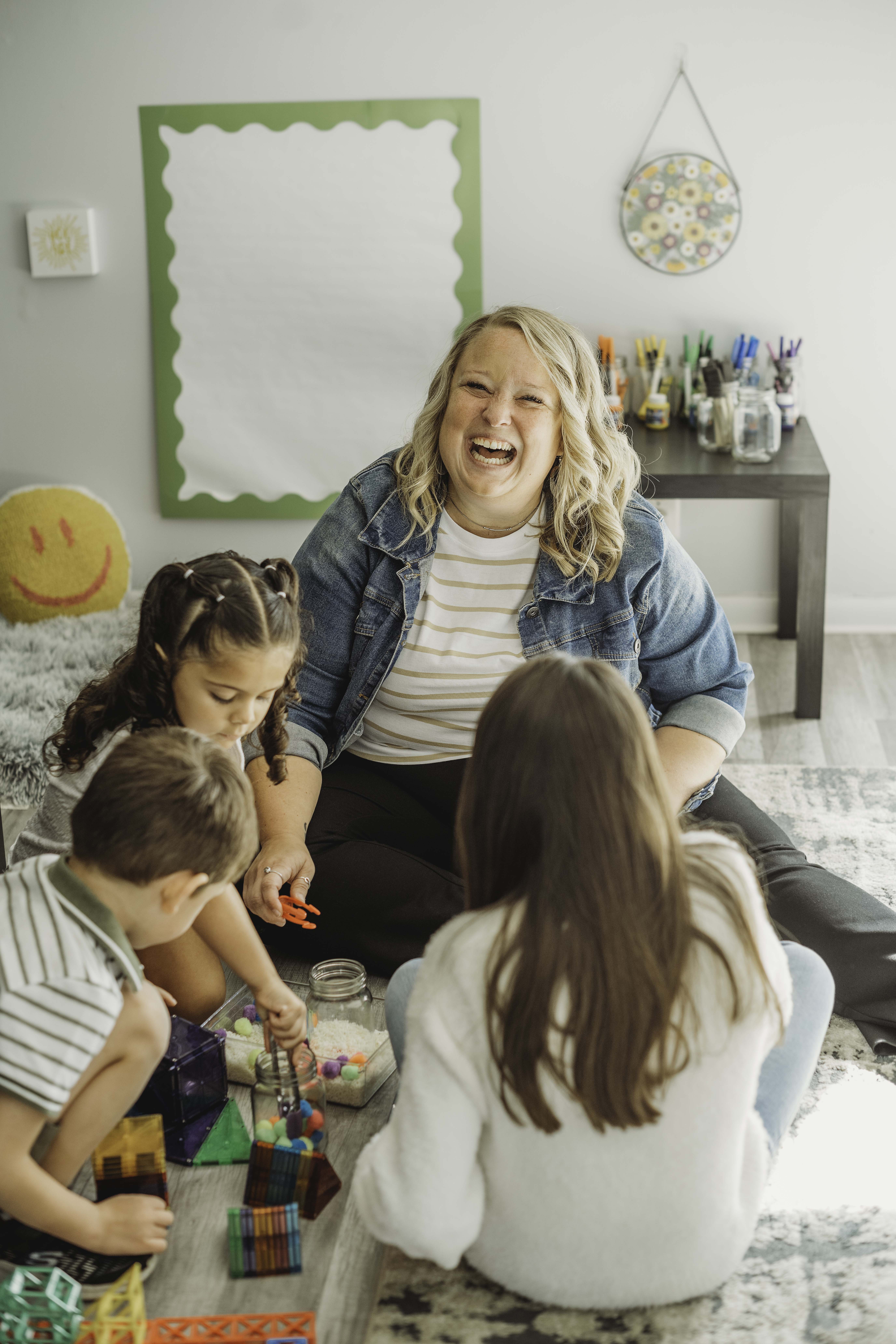 A student wearing a red uniform sits while holding a book in his hands
