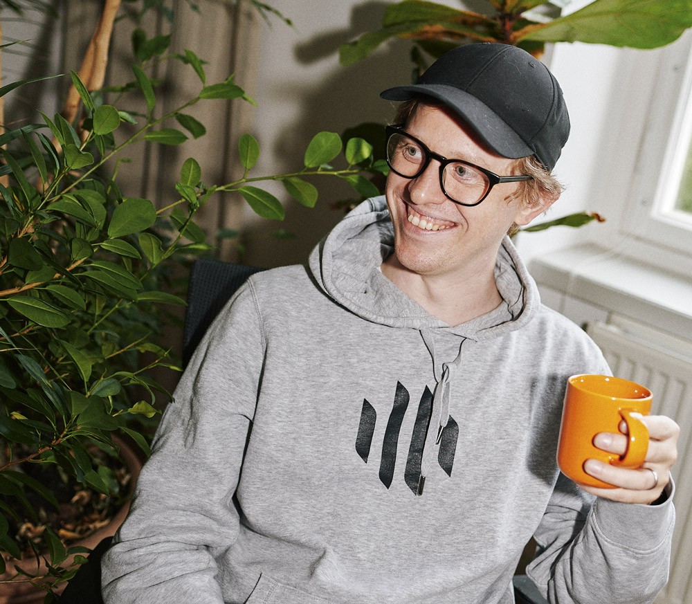 Erik Von Krusenstierna laughing with a orange coffee mug on his hand