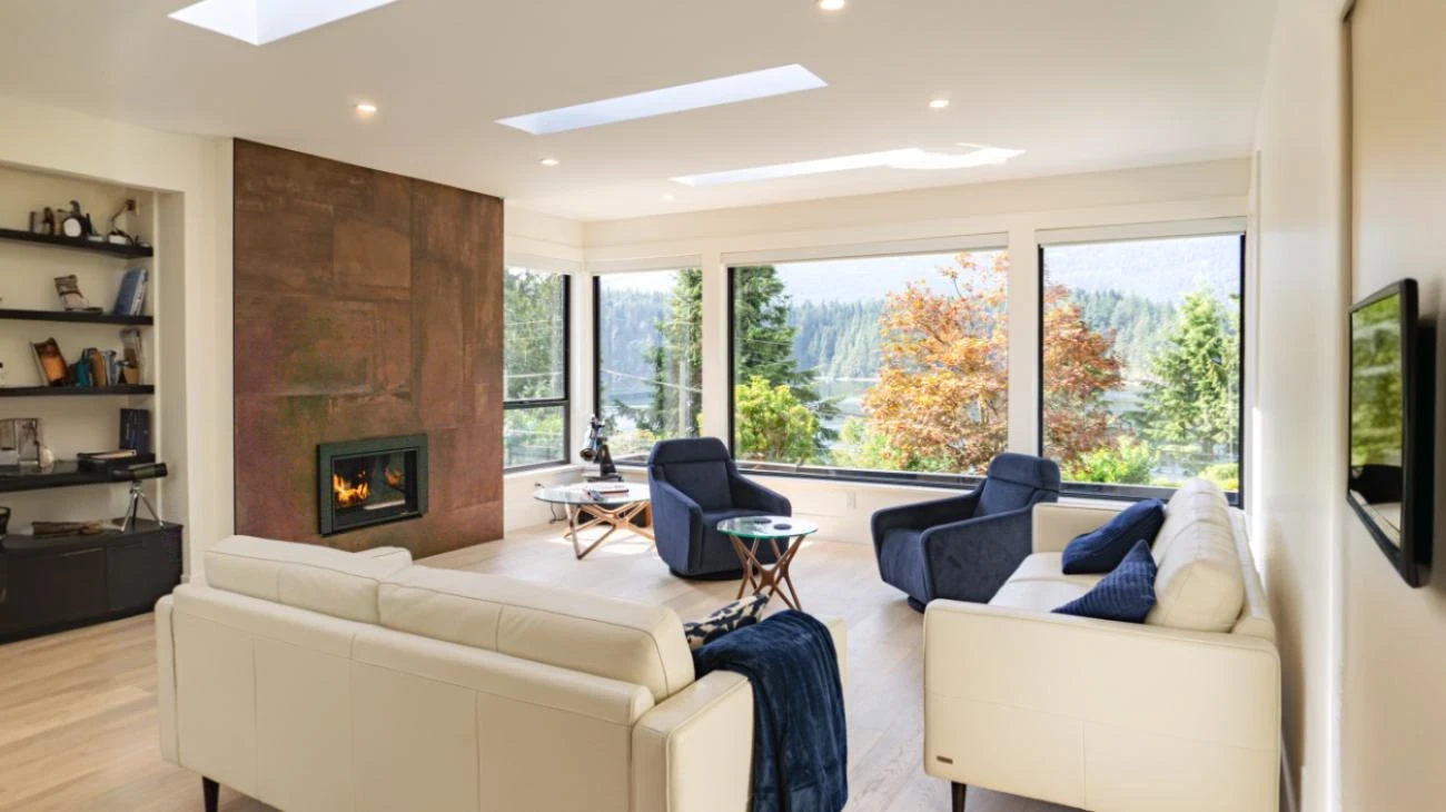 Luxury living room with floor-to-ceiling wood-clad fireplace, large windows, built-in shelving, and modern furnishings in Vancouver custom home