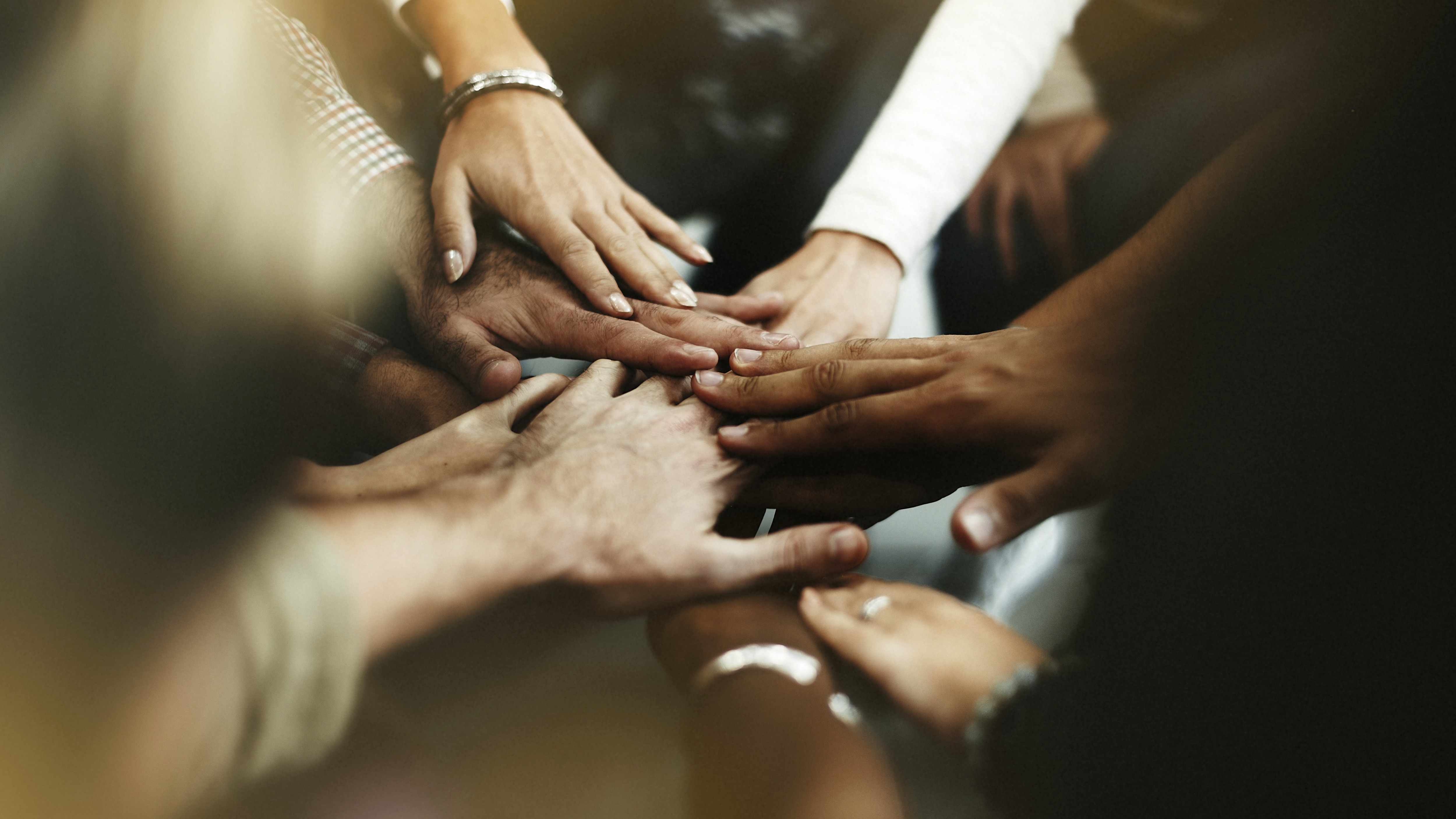 a group of people putting their hands together in a circle