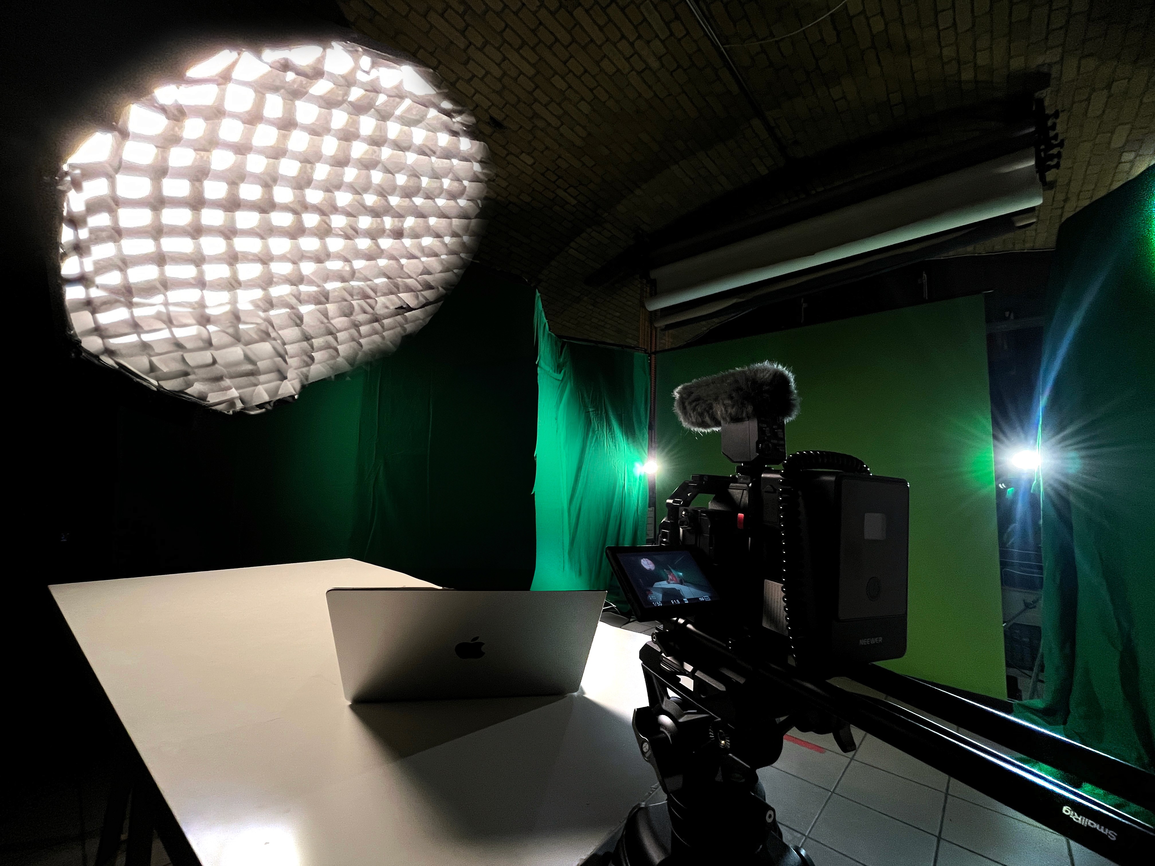 A large group photo of diverse team members gathered in an industrial-style space with arched ceiling.