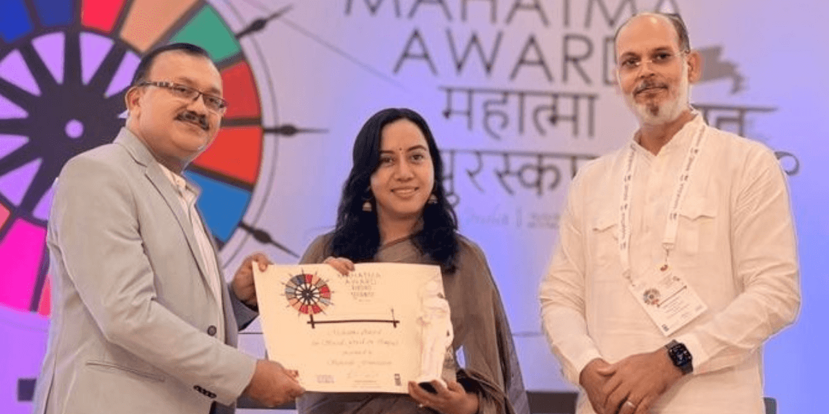 Three individuals at Mahatma Awards ceremony; Dr. Geeta Bora of Spherule Foundation receives Best Social Impact Organization 2025 recognition.