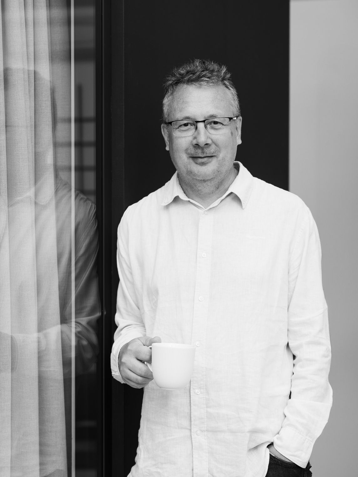 Man in a suit with arms crossed against orange background