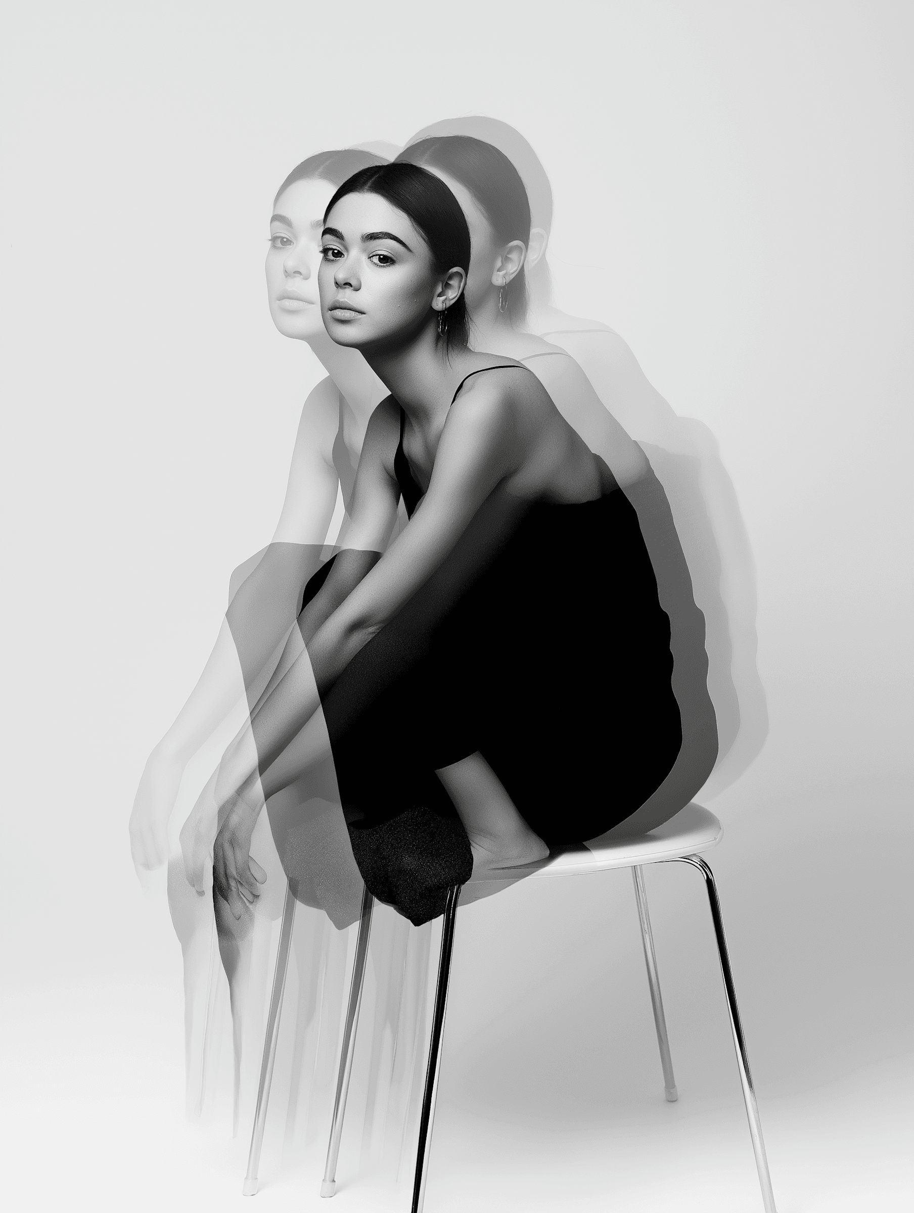 Black and white woman seated on a stool with blurred effect