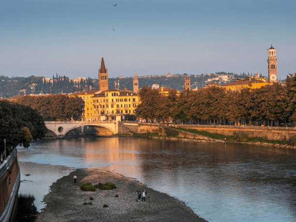 Locals enjoying a calm evening walk along the Verona riverfront