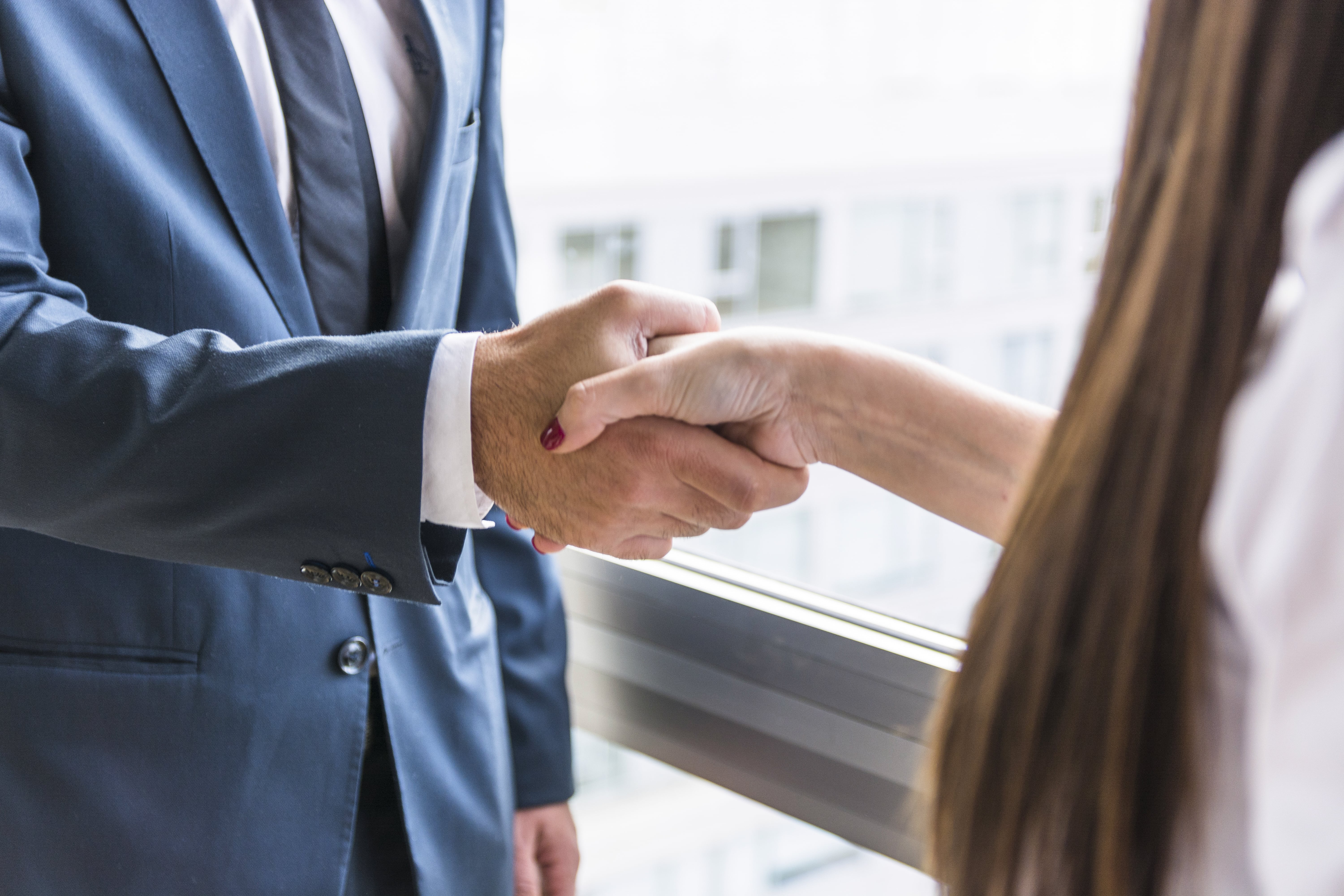 close-up-businesswoman-businessman-shaking-hands