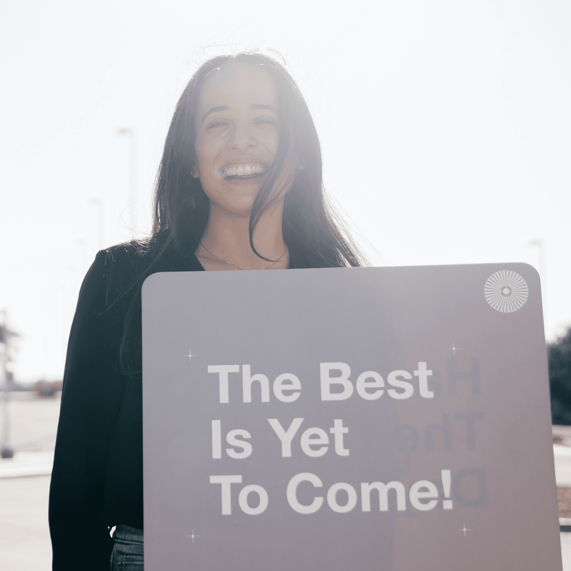 A woman smiling, welcoming you to church.