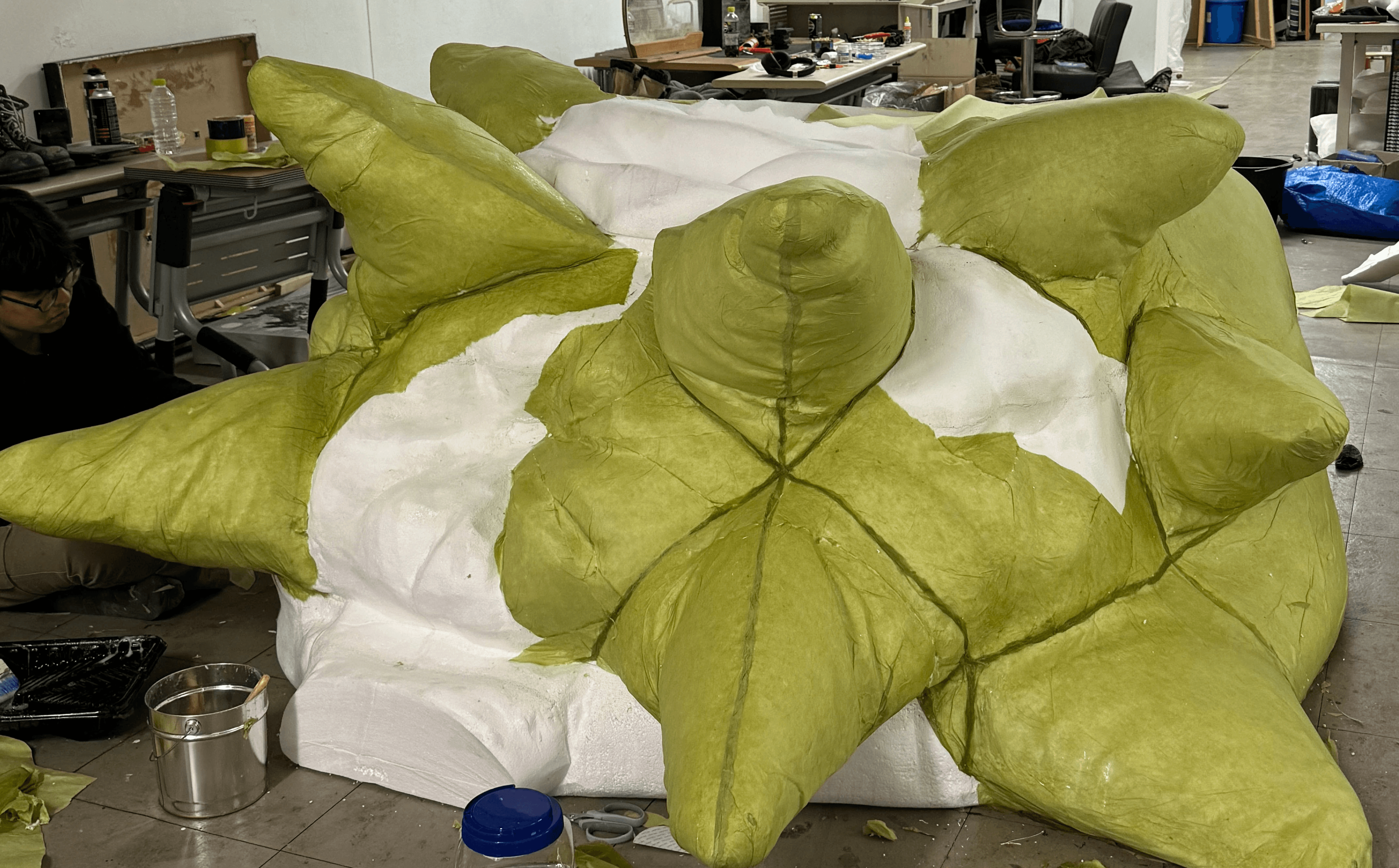 스티로폼 위 패브릭 소재를 접착하는 표면 처리 단계 — KiiiKiii MV 조형물 제작 / Fabric surface layering over styrofoam base — large-scale sculpture fabrication for KiiiKiii MV