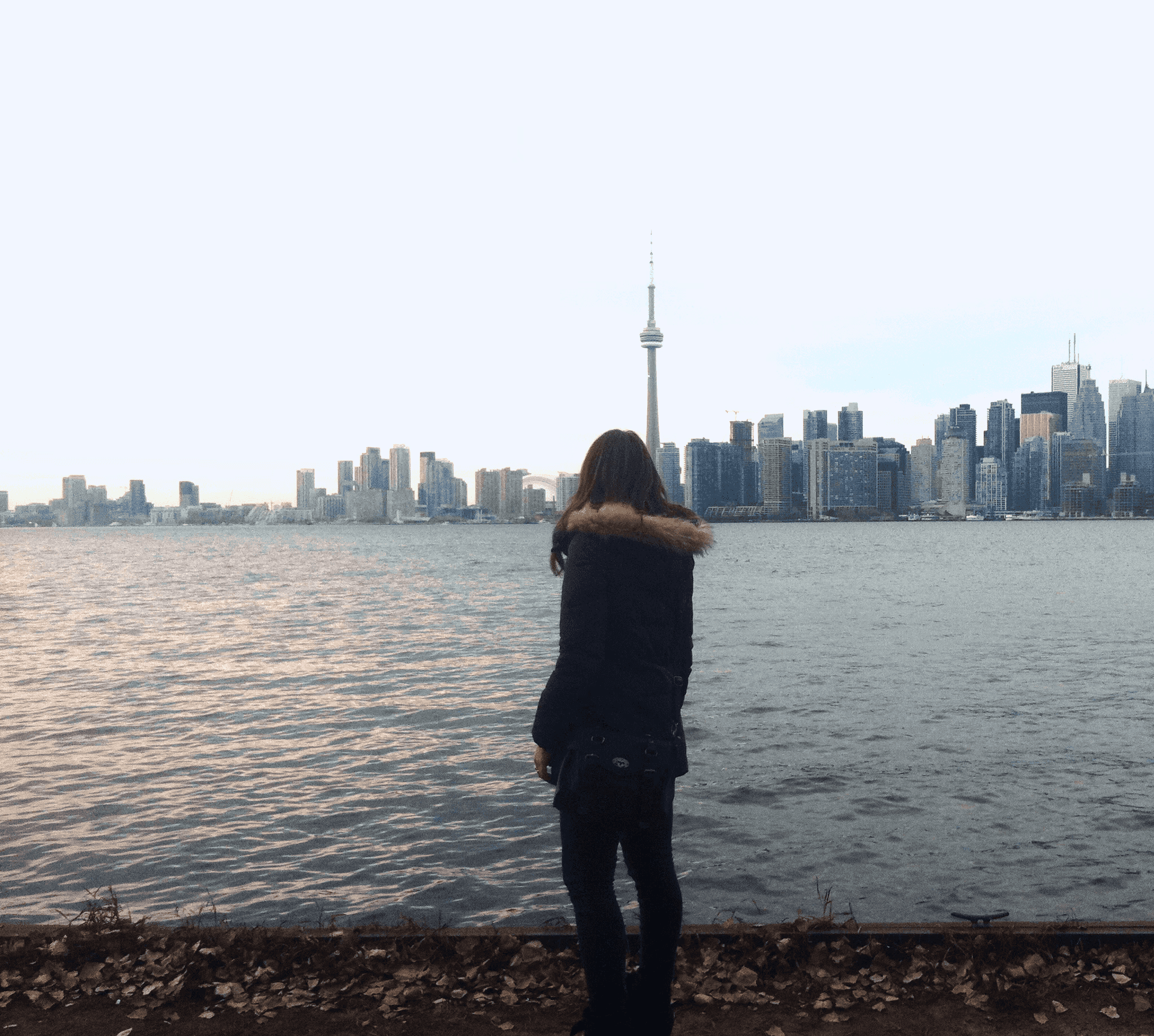 a-woman-looking-at-CNTower-Toronto-bay-skyline