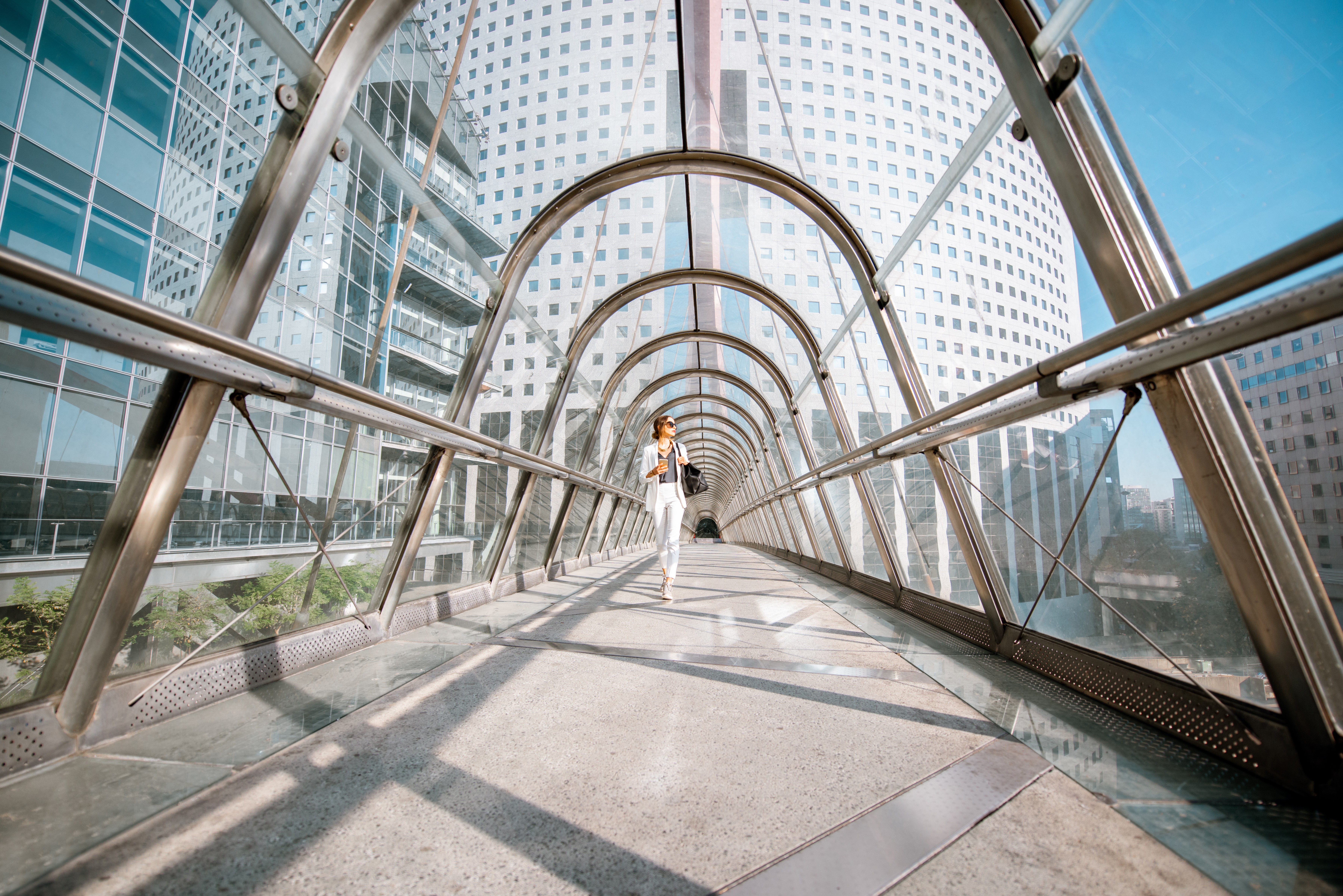 Woman walking through modern covered bridge representing bridging finance solutions