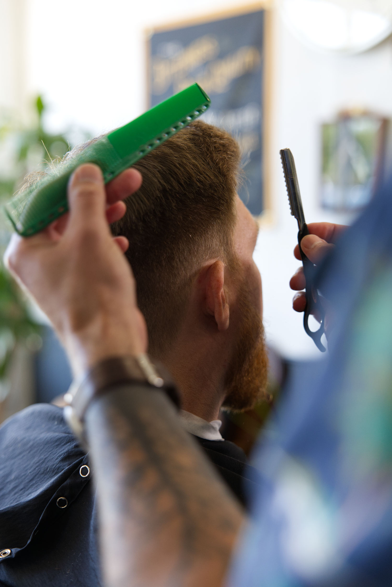 Barber cutting and styling hair at Calderone's Barbershop in Geneva IL