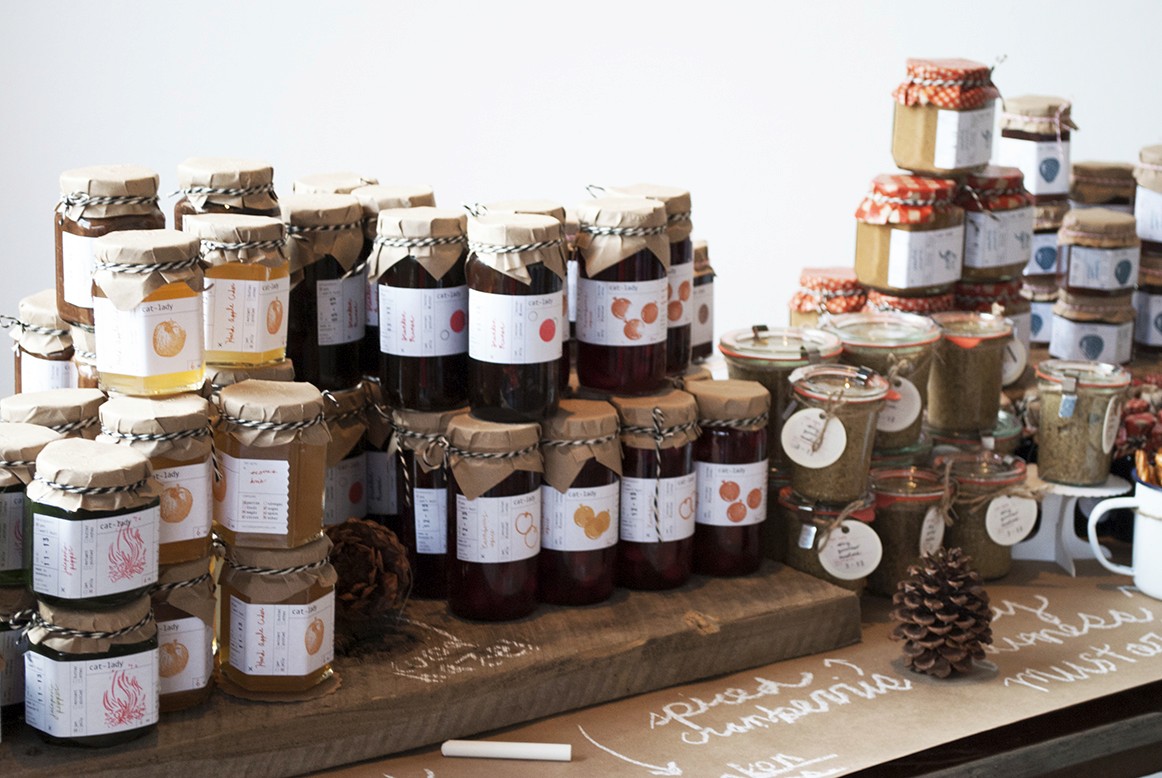 A photo with some jars that have different design labels on them.