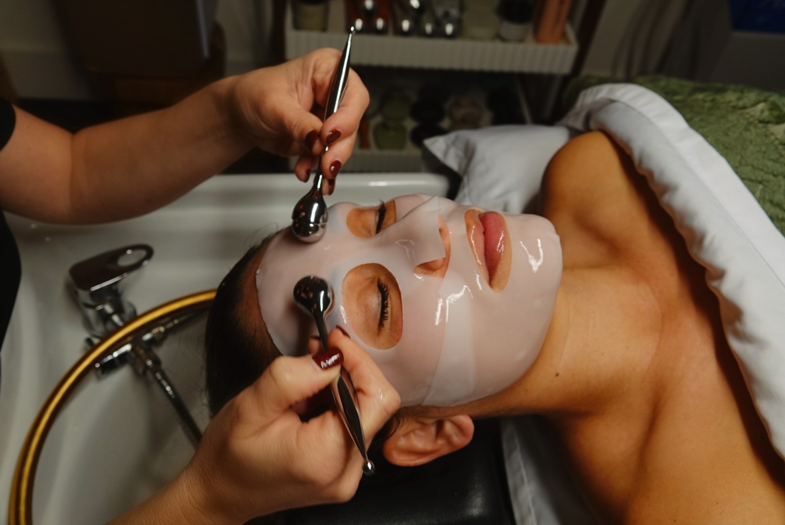 Person receiving facial with mask and cold globes
