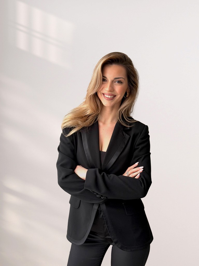 Woman in oversized suit poses for a portrait.