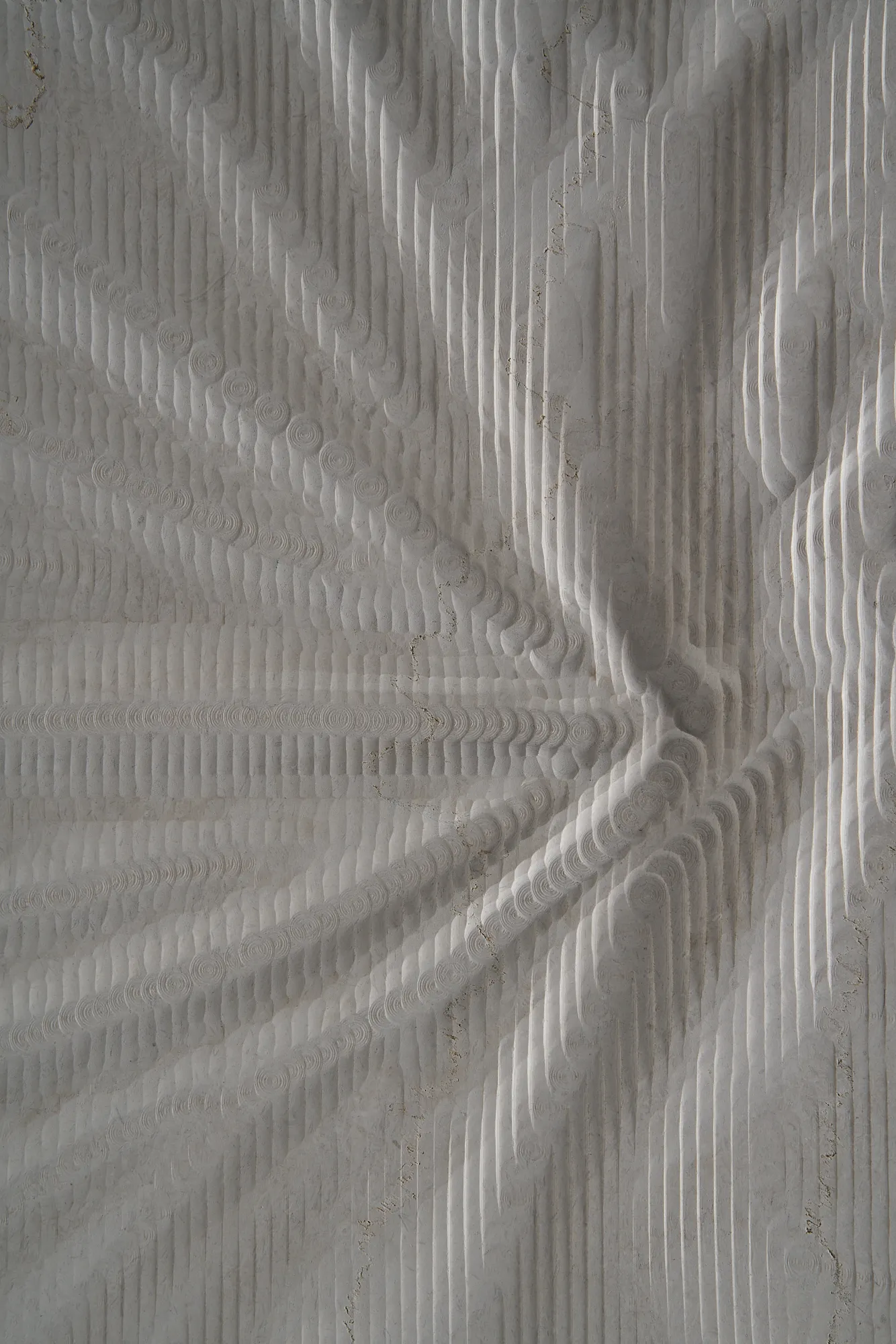 Detailed view of a Curtis natural stone panel with radiating fabric-like creases and textured carved lines.