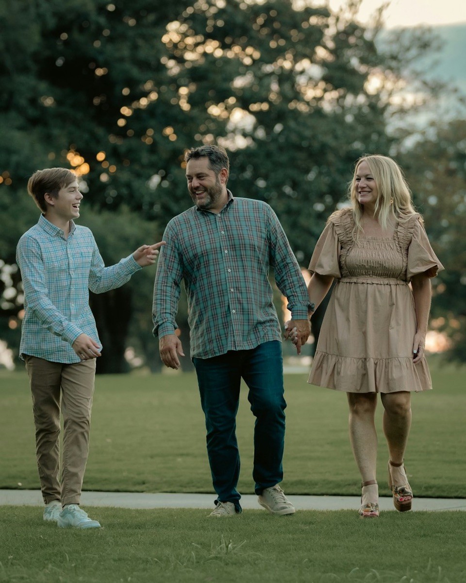 Una familia paseando de la mano por un parque