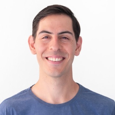 a man in a blue shirt smiling at the camera