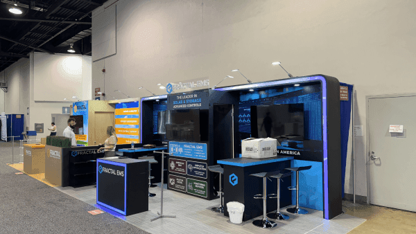 Fractal RE+ Southeast 2024 solar and battery booth with branded presentation wall, technical product display, meeting counter, and clean energy visitor flow