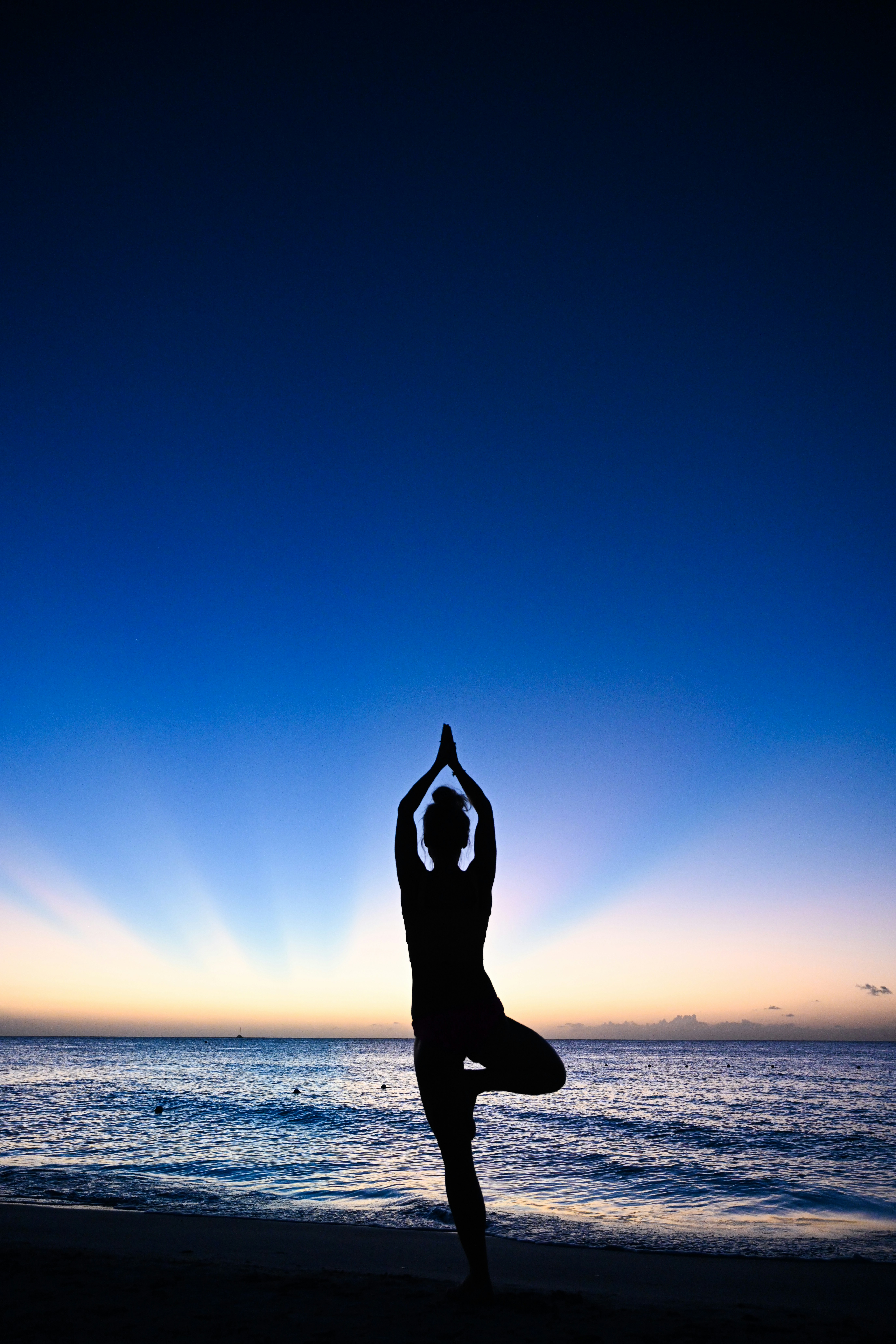 a person doing yoga on the beach at sunset