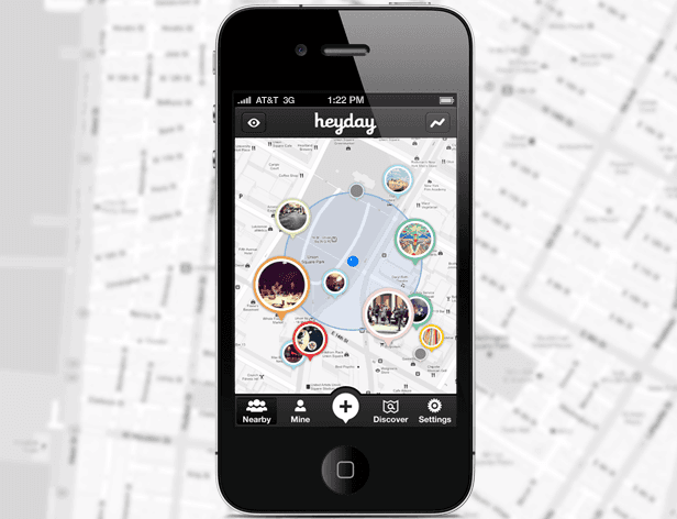 A black iPhone displays a map application interface titled “heyday” at the top center. The map shows a circular layout with several colored circles containing images and text. Below the map are four tabs: “Nearby,” “Mine,” “+,” and “Discover.” At the bottom is a central button labeled “Settings.” The phone’s top bar displays AT&T 3G network connection and time as 1:22 PM. The background is blurred and appears to be a map with street markings.