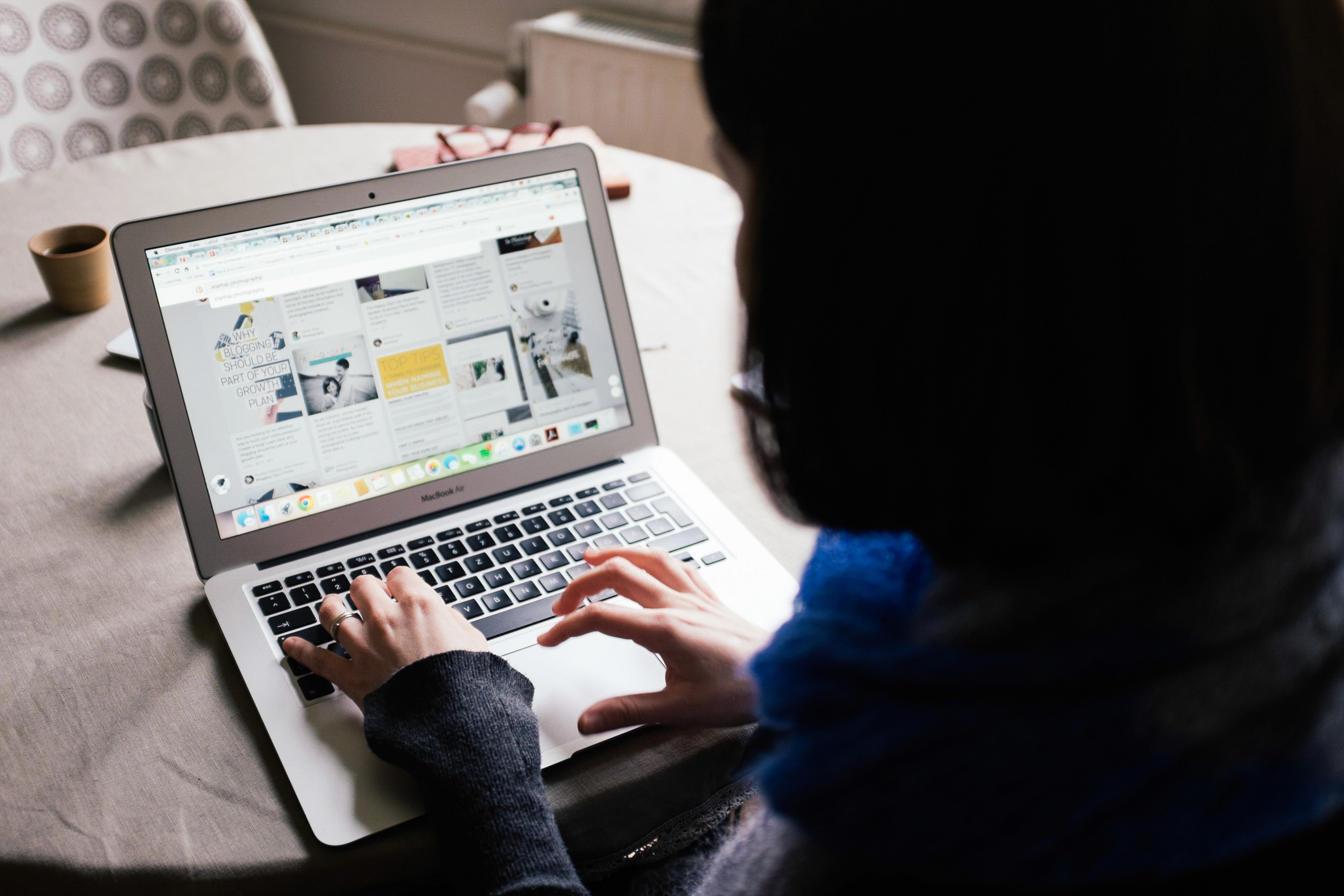 two people in a workspace working on their laptops 