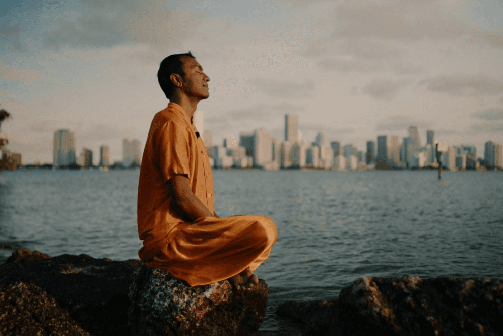Sri Sudarshan Sitting on a shore performing yoga