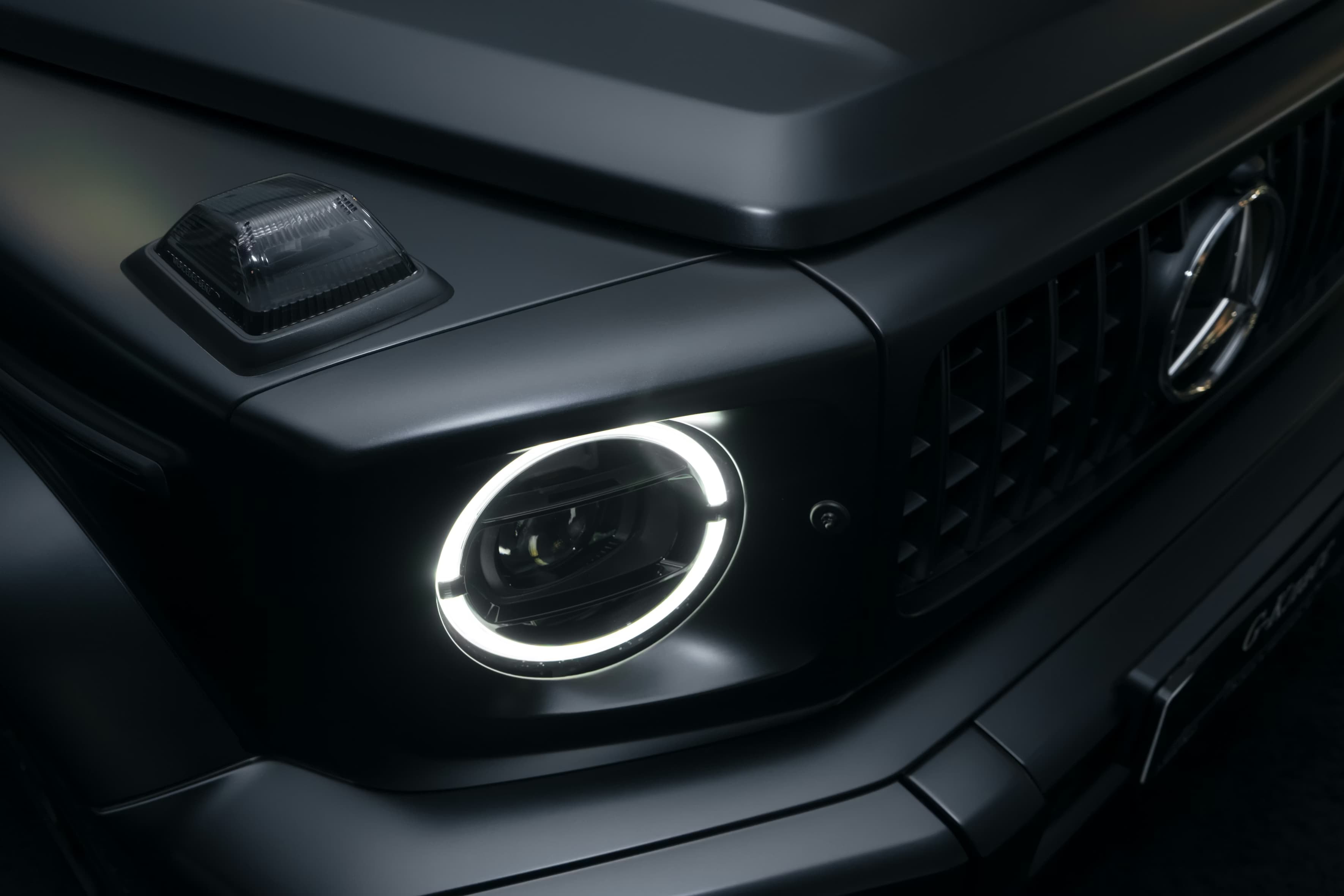 Face avant d’un Mercedes Classe G noir mat dans un univers premium