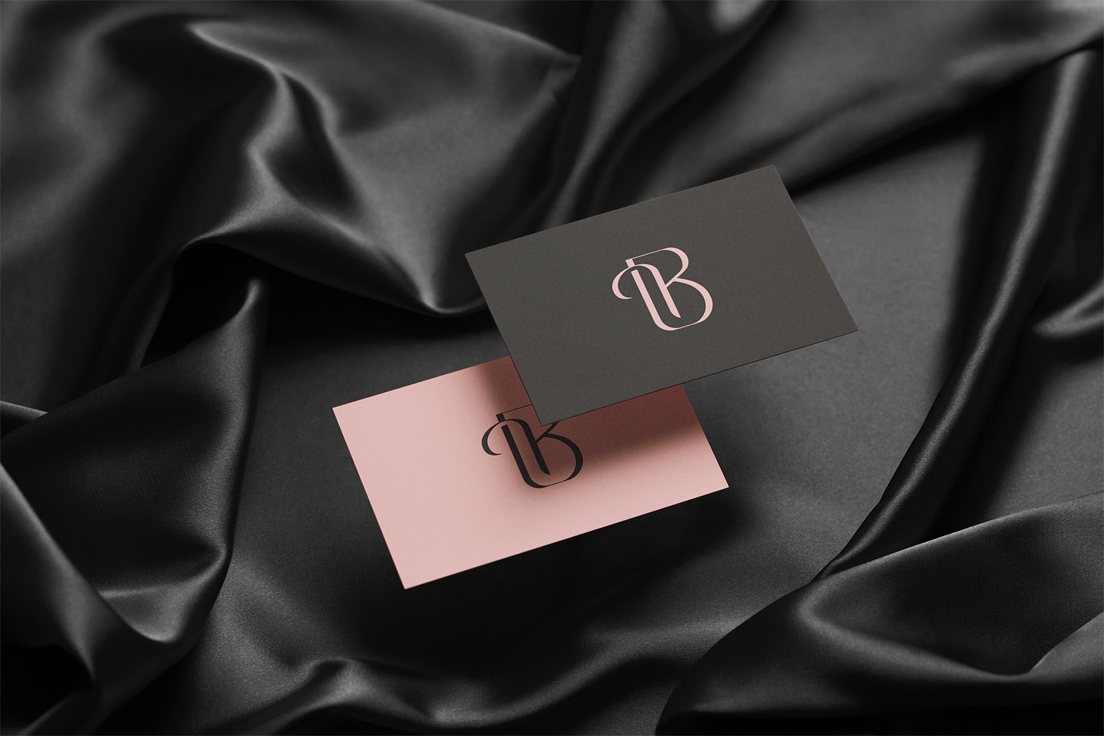 Two business cards hovering over a satin sheet