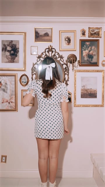 A guest posing in front of the gallery wall