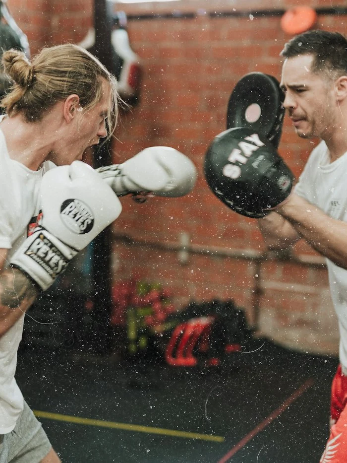 A coach holding pads for a boxer
