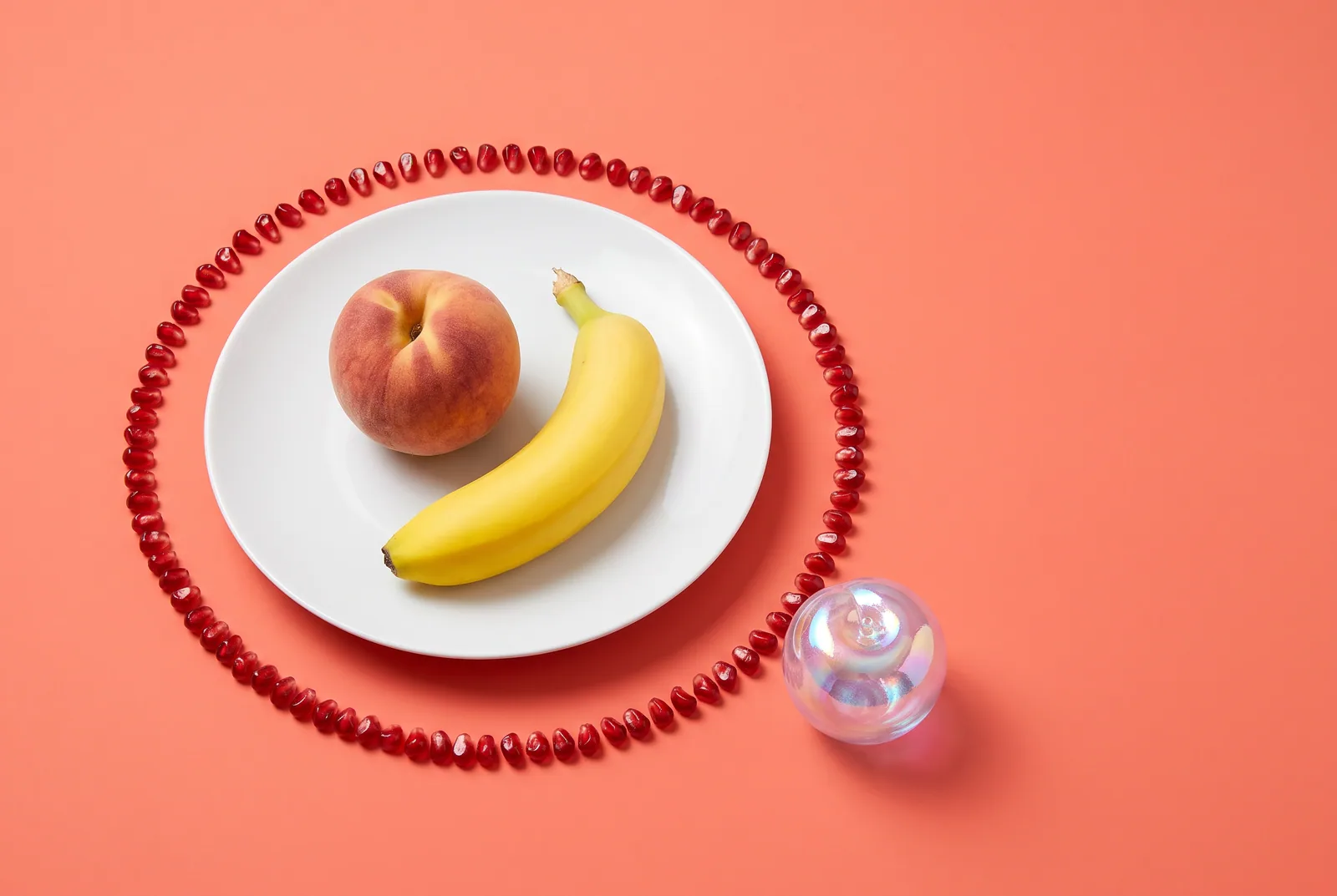 A peach and a banana on one plate inside a border of pomegranate seeds, with a holographic glass plum left outside, a metaphor for AI cheating boundaries