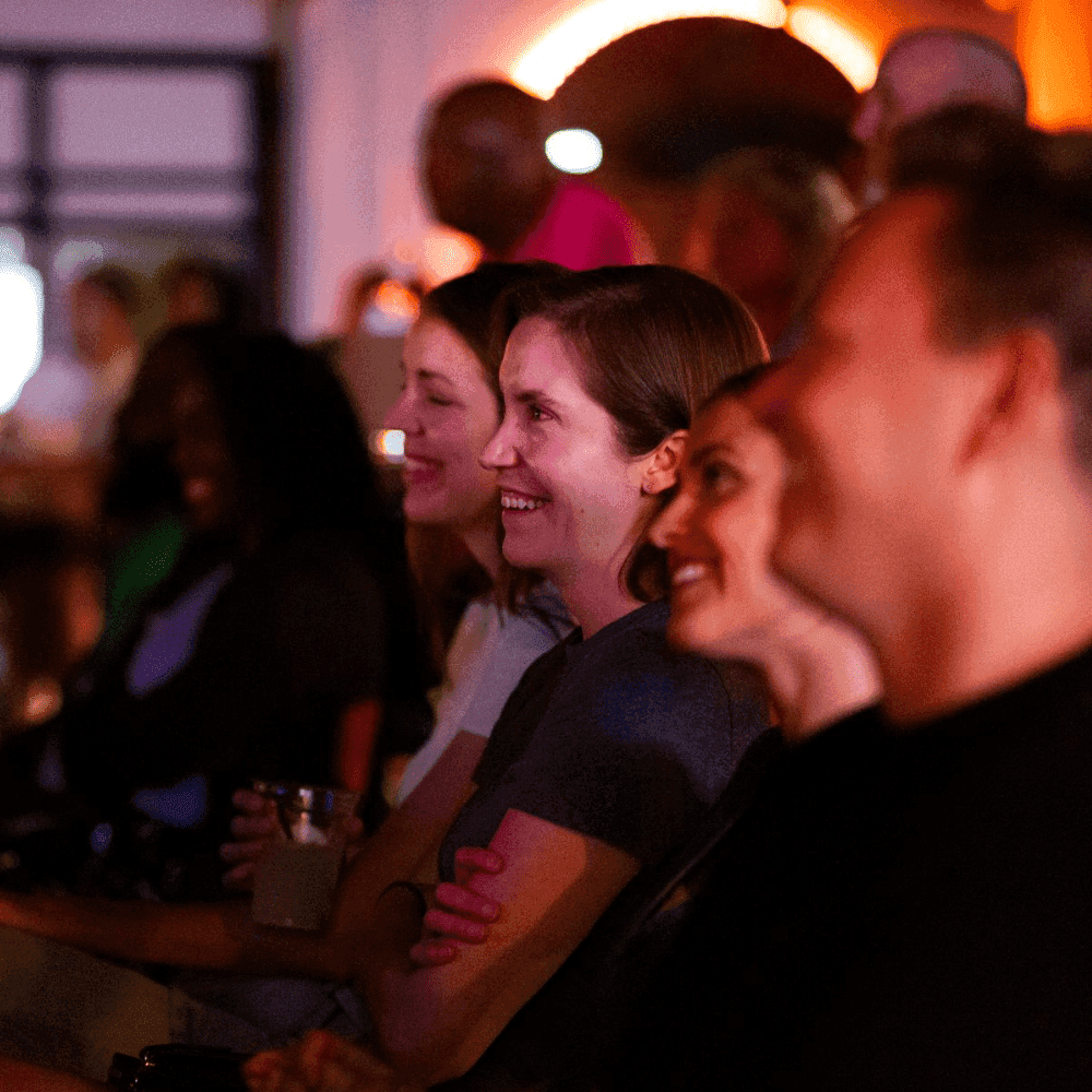An entire row of men and women laughing at a St Pete Standup show
