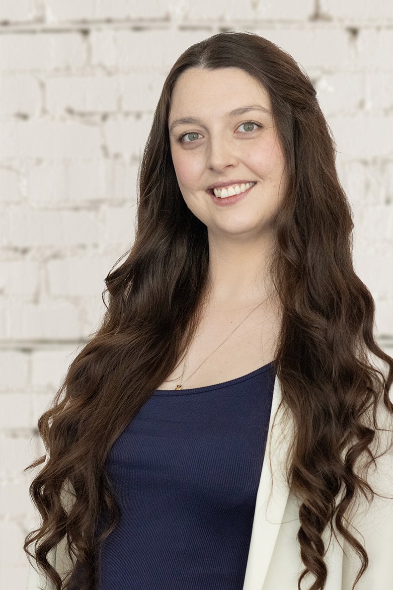 Image of a fair skinned woman with long flowing brown hair smiling at the camera.