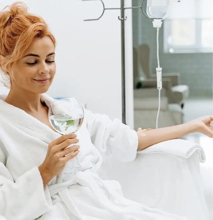 Woman receiving IV drip therapy at wellness clinic.