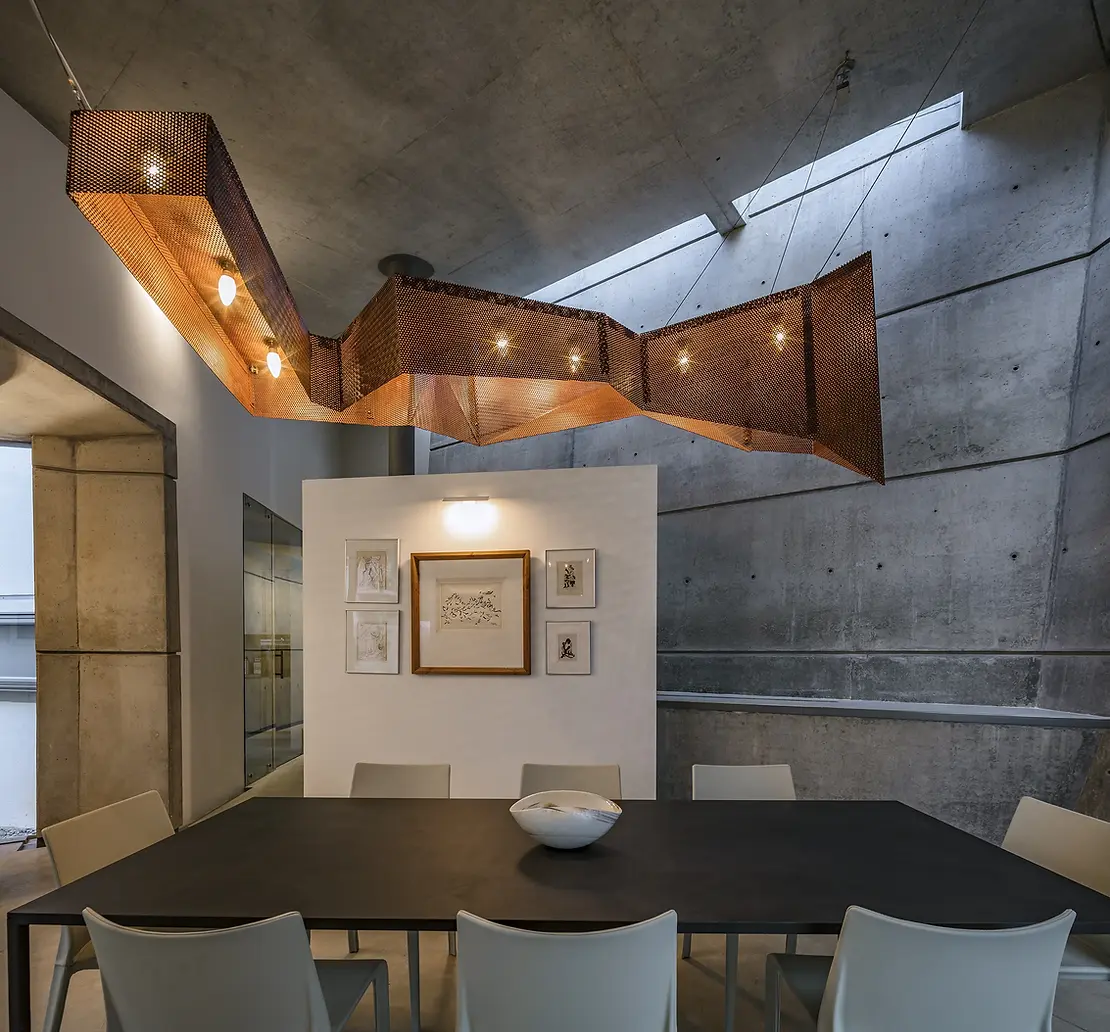 The elegant dining space features an impressive metal and wood lighting fixture at House of Stories