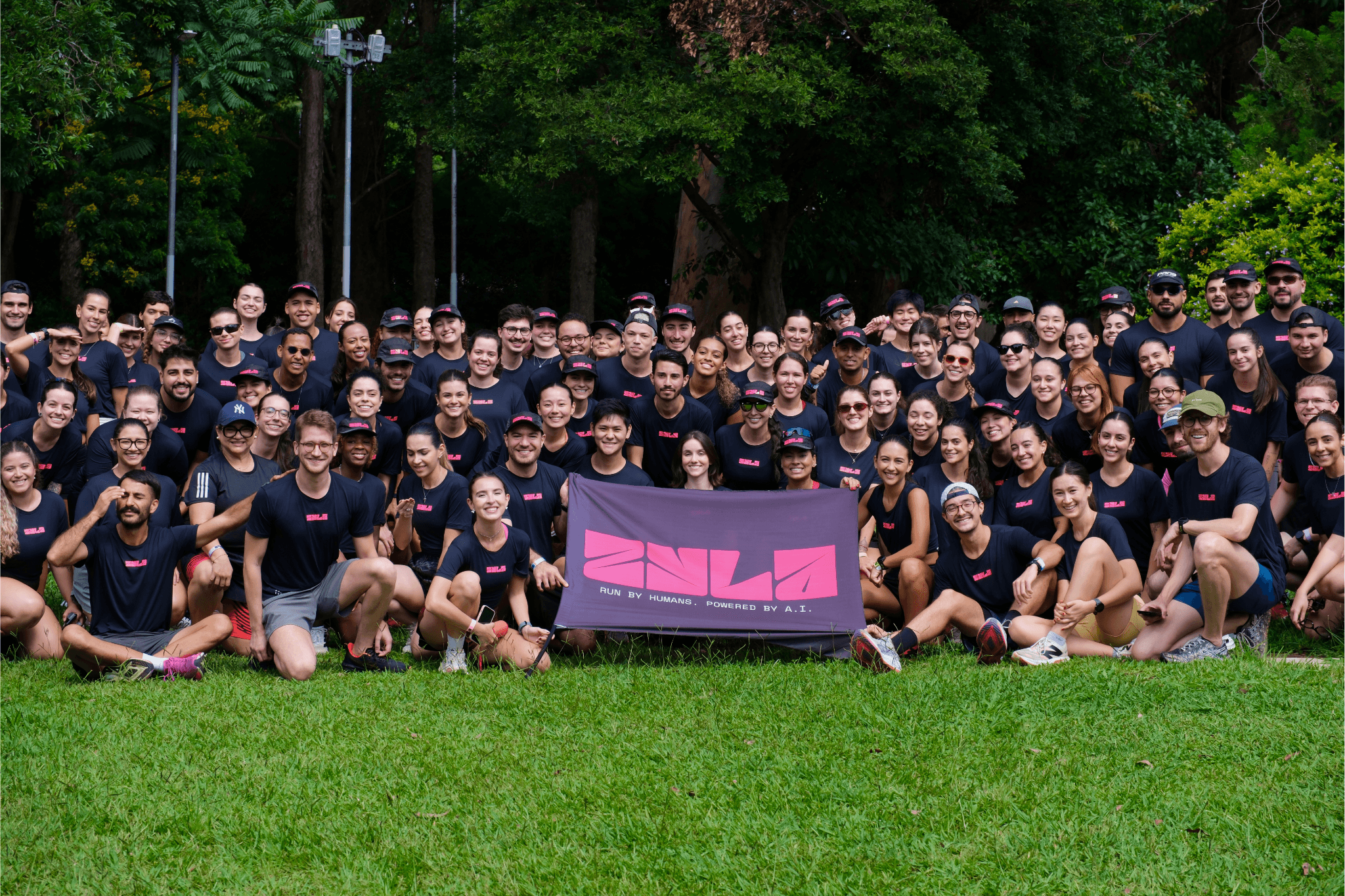 woman in black tank top and white pants lying on green grass field during daytime