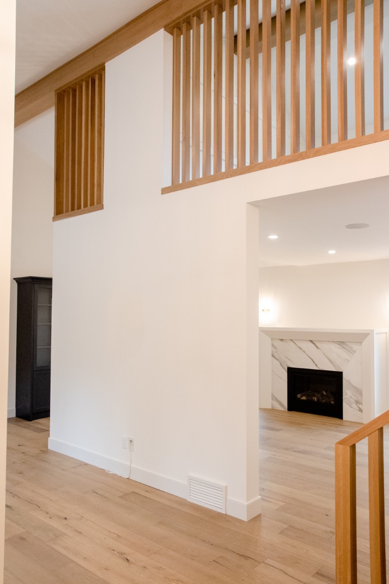 Image of KHD Homes interior design featuring wooden accents and layout design with a marble fireplace.