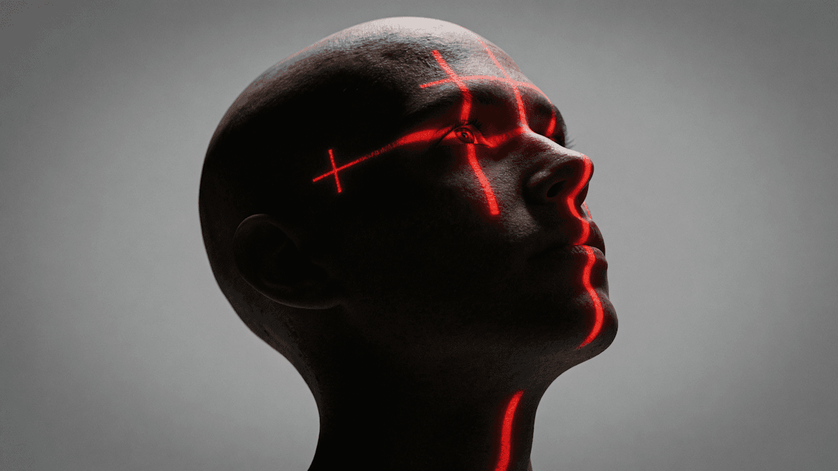 A man with red lines painted across his face, creating a striking and artistic appearance.