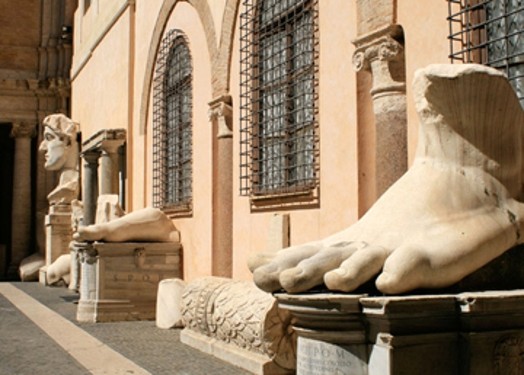 A photo of some carved stones on display, showing human body parts and stone pillars.