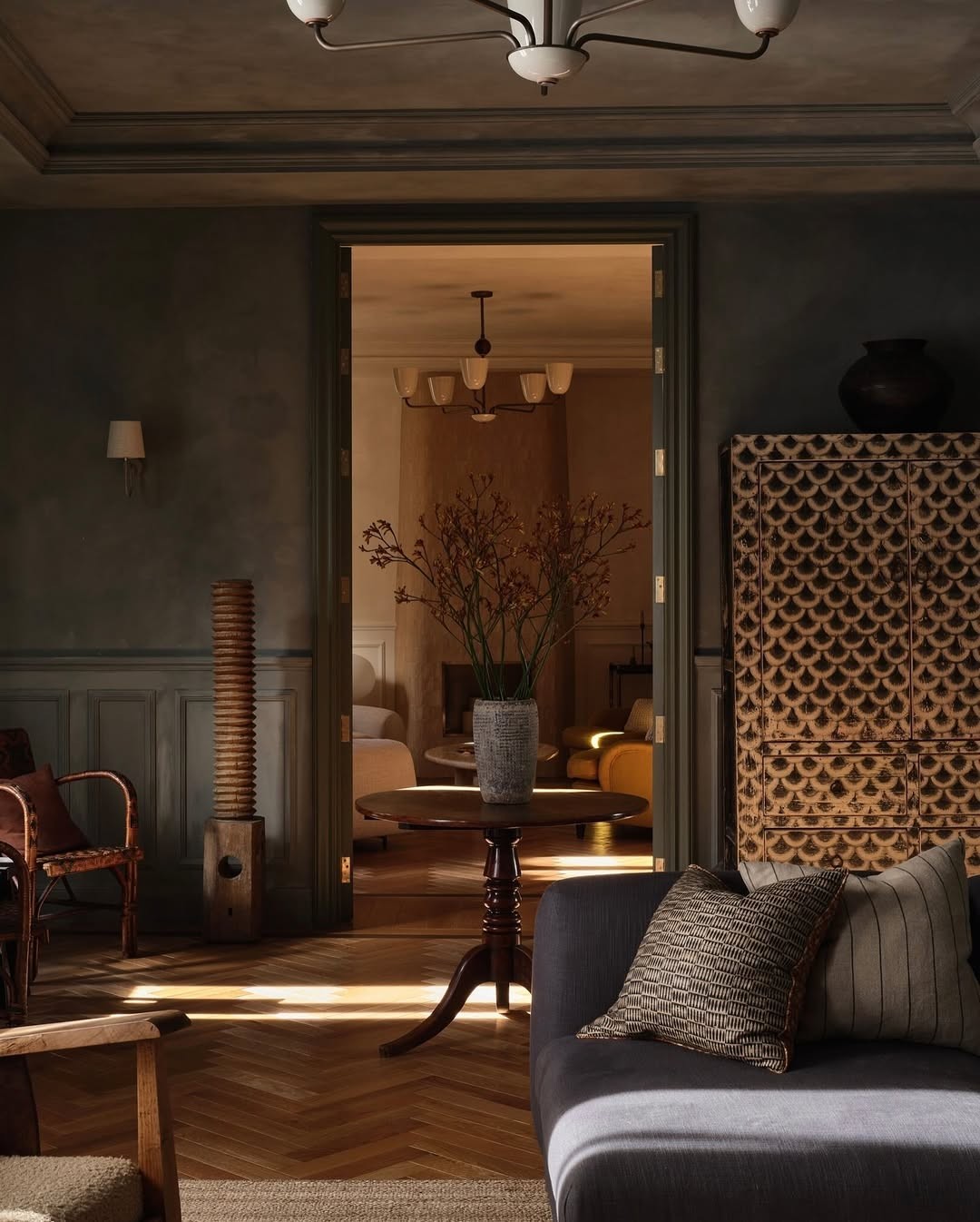 Warm lounge with a wall of records, large speakers, leather chairs, and a round table.