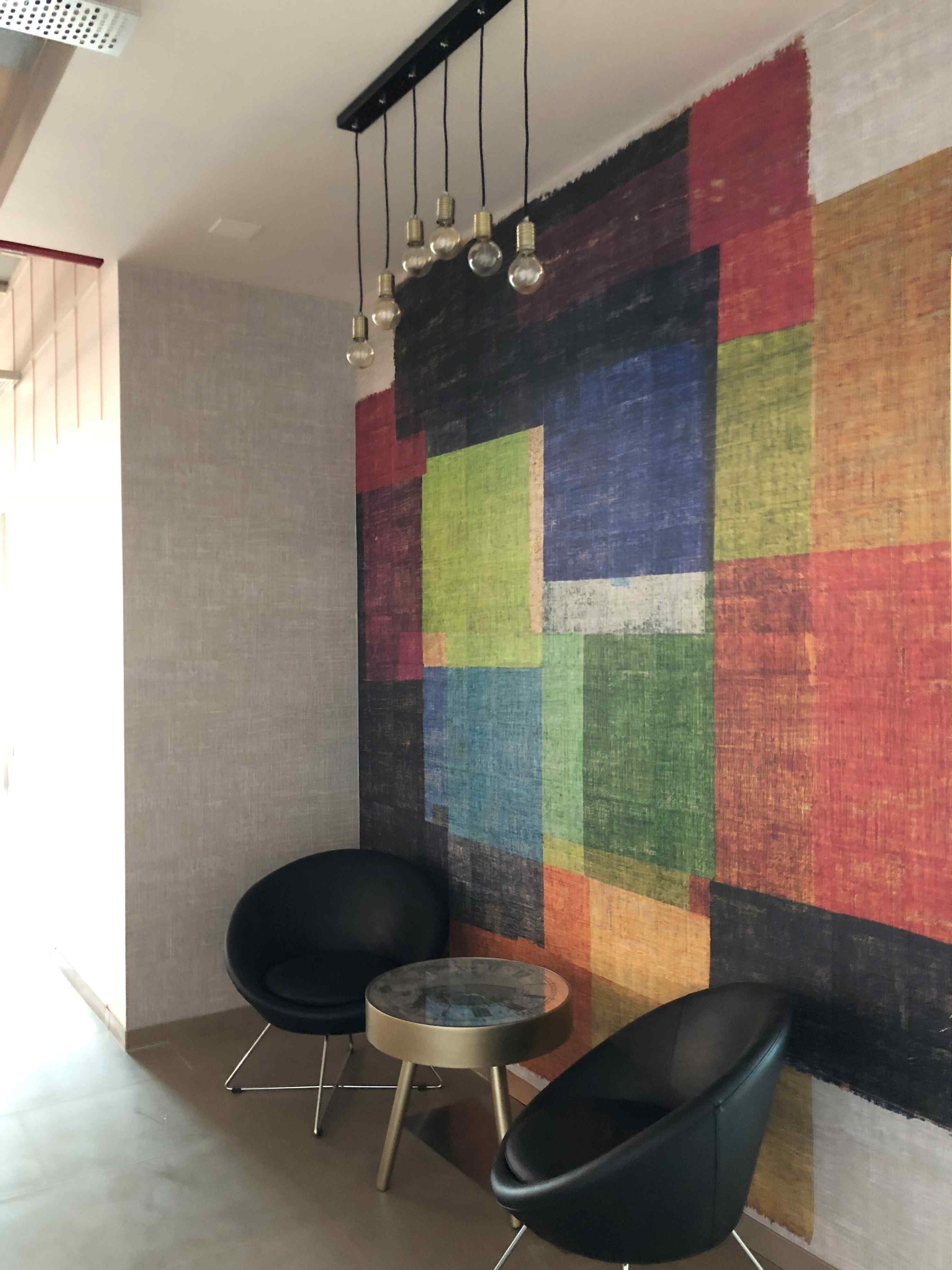 Nature-inspired preschool entrance with sculptural tree partitions and suspended green leaf ceiling panels.